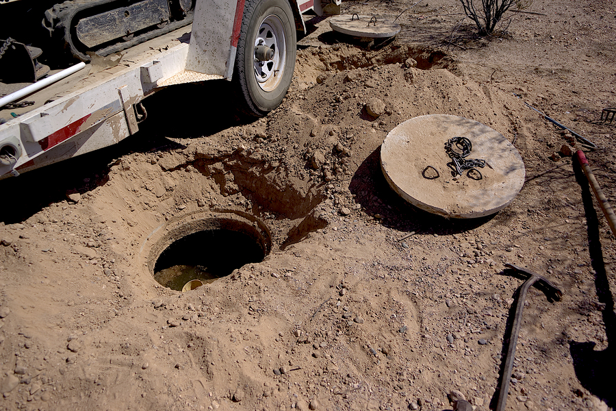 septic tank with its lids uncovered in preparation of having the waste inside pumped out.